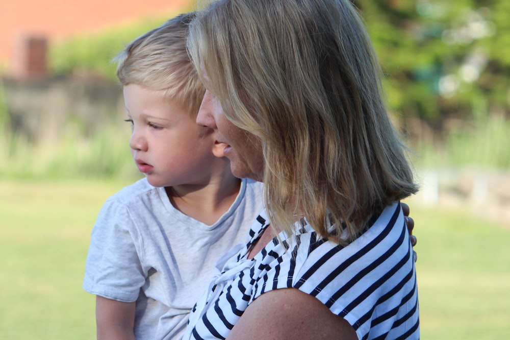 girl in white and blue stripe shirt kissing woman in white shirt