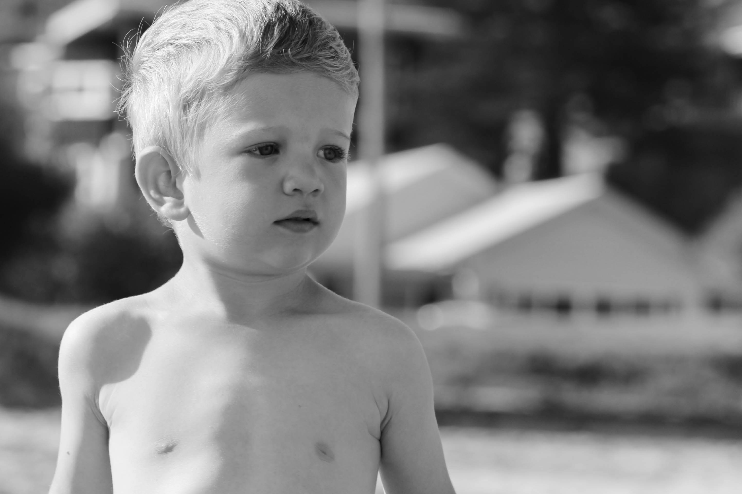 topless child standing on the field