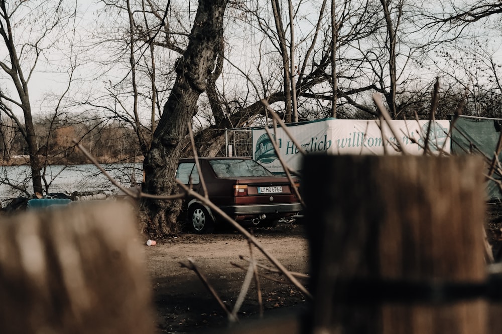 red suv parked beside tree