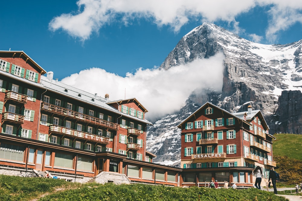 Braunes Betongebäude in der Nähe eines schneebedeckten Berges unter blauem Himmel tagsüber