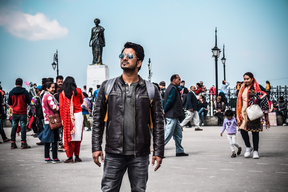 man in black leather jacket standing on the street