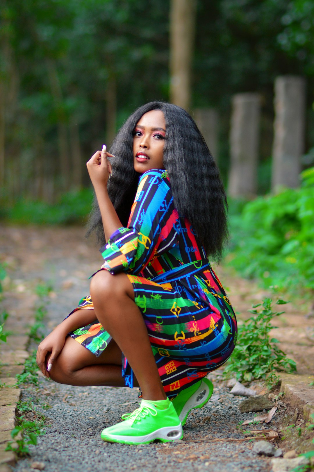 woman in blue yellow and red dress sitting on ground