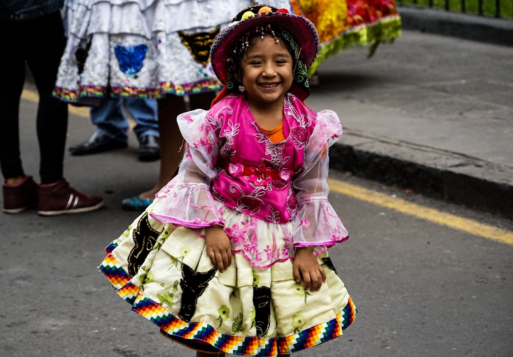 girl in pink and white floral dress wearing brown woven hat