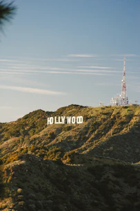 The Hollywood sign on a grassy hillside in Los Angeles under a clear sky