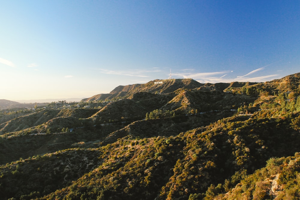 montagnes vertes et brunes sous le ciel bleu pendant la journée