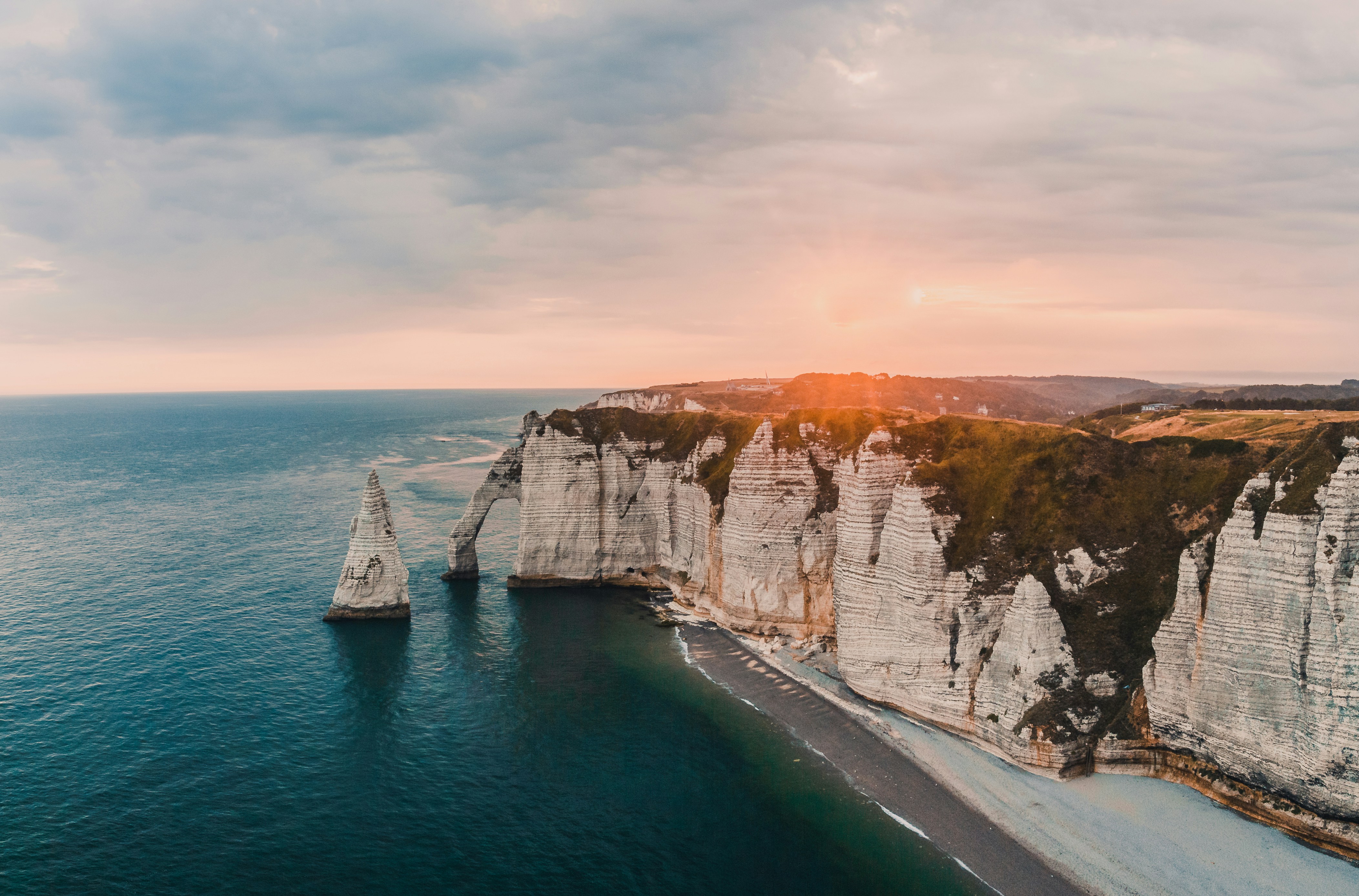 weiße und braune Felsformation neben dem Gewässer tagsüber