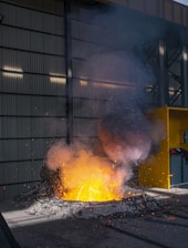 A panoramic view of the industrial recycling plant with molten aluminum glowing in the smelting furnace.