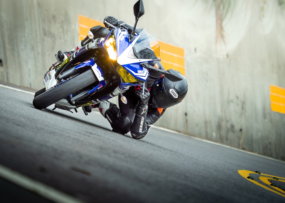 man in yellow and black motorcycle suit riding yellow sports bike