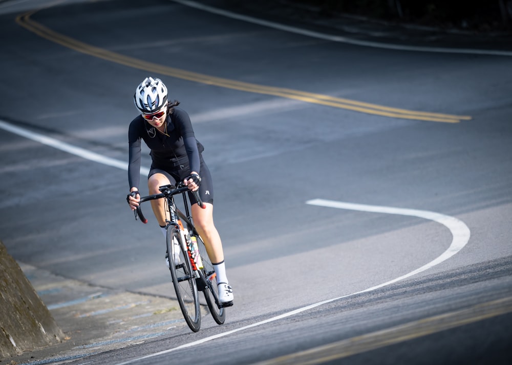 homme au casque noir et blanc à vélo