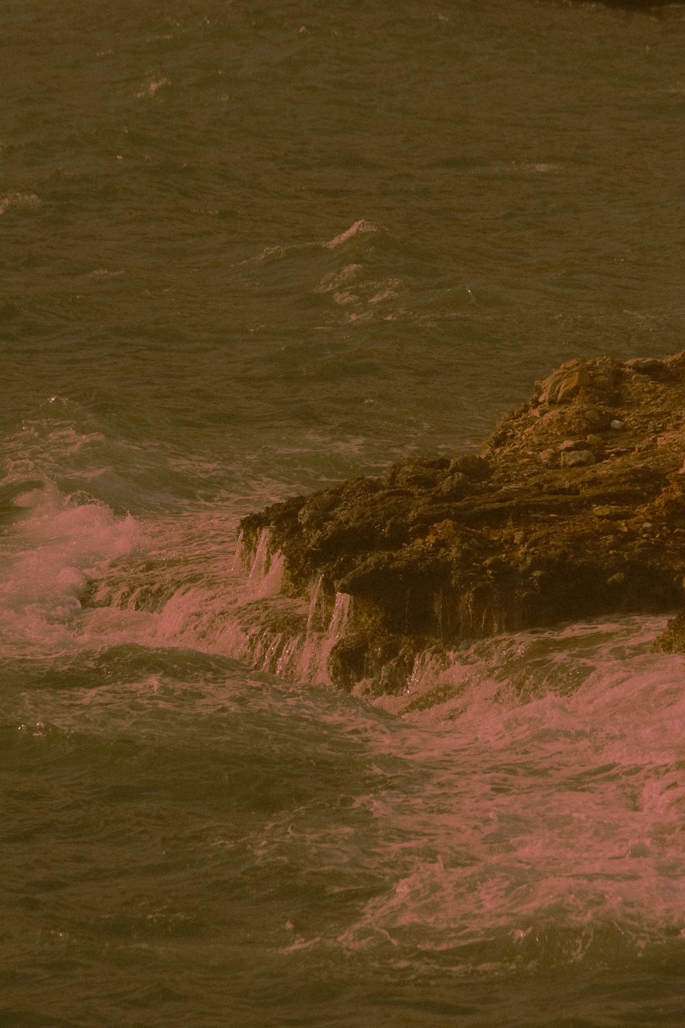 brown rock formation beside body of water during daytime