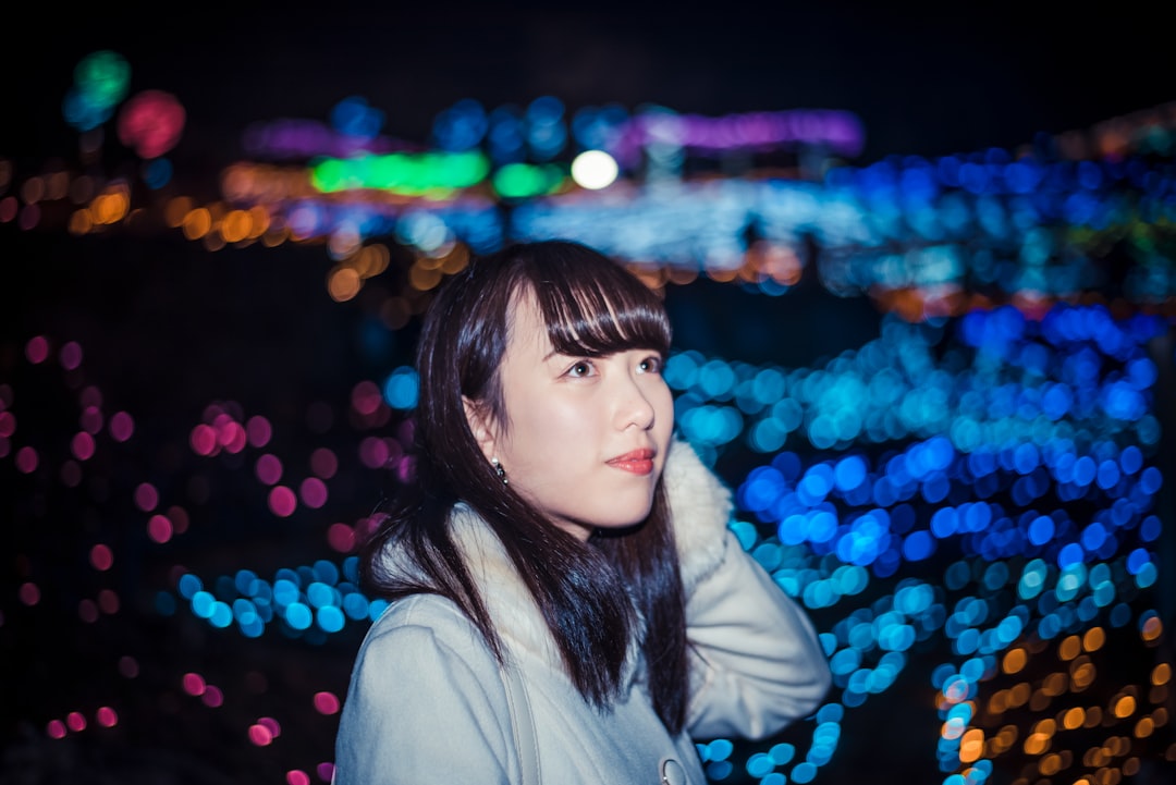 woman in white coat standing near blue and red lights