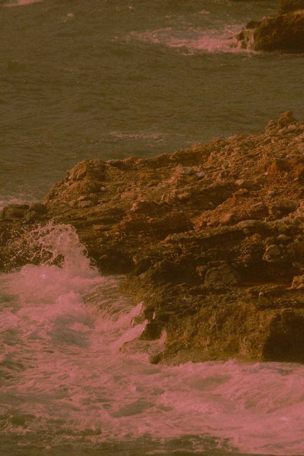 brown rock formation on body of water during daytime