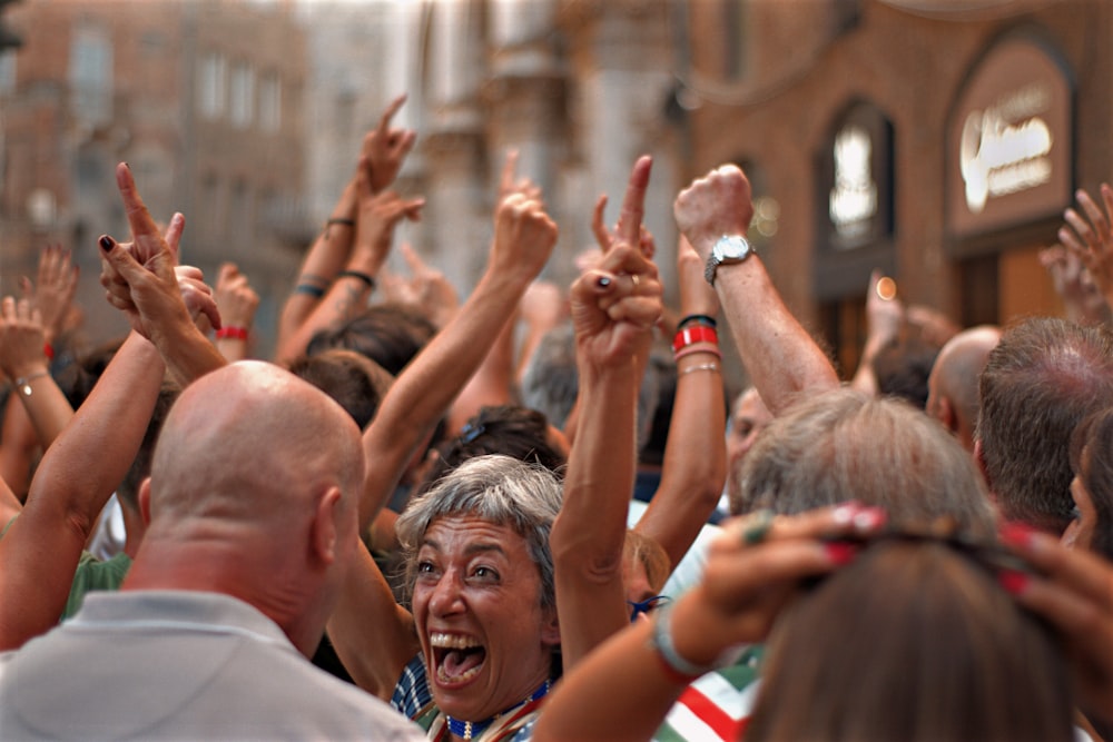 people raising their hands during daytime