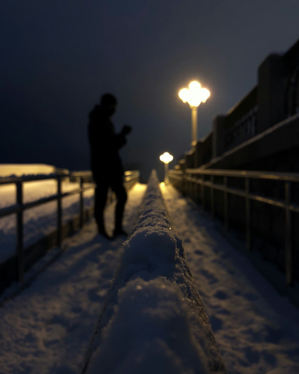 man in black jacket standing on snow covered ground during night time