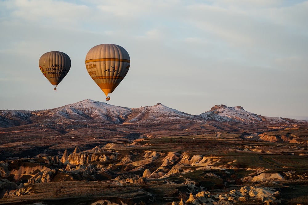 hot air balloon flying over the mountains during daytime