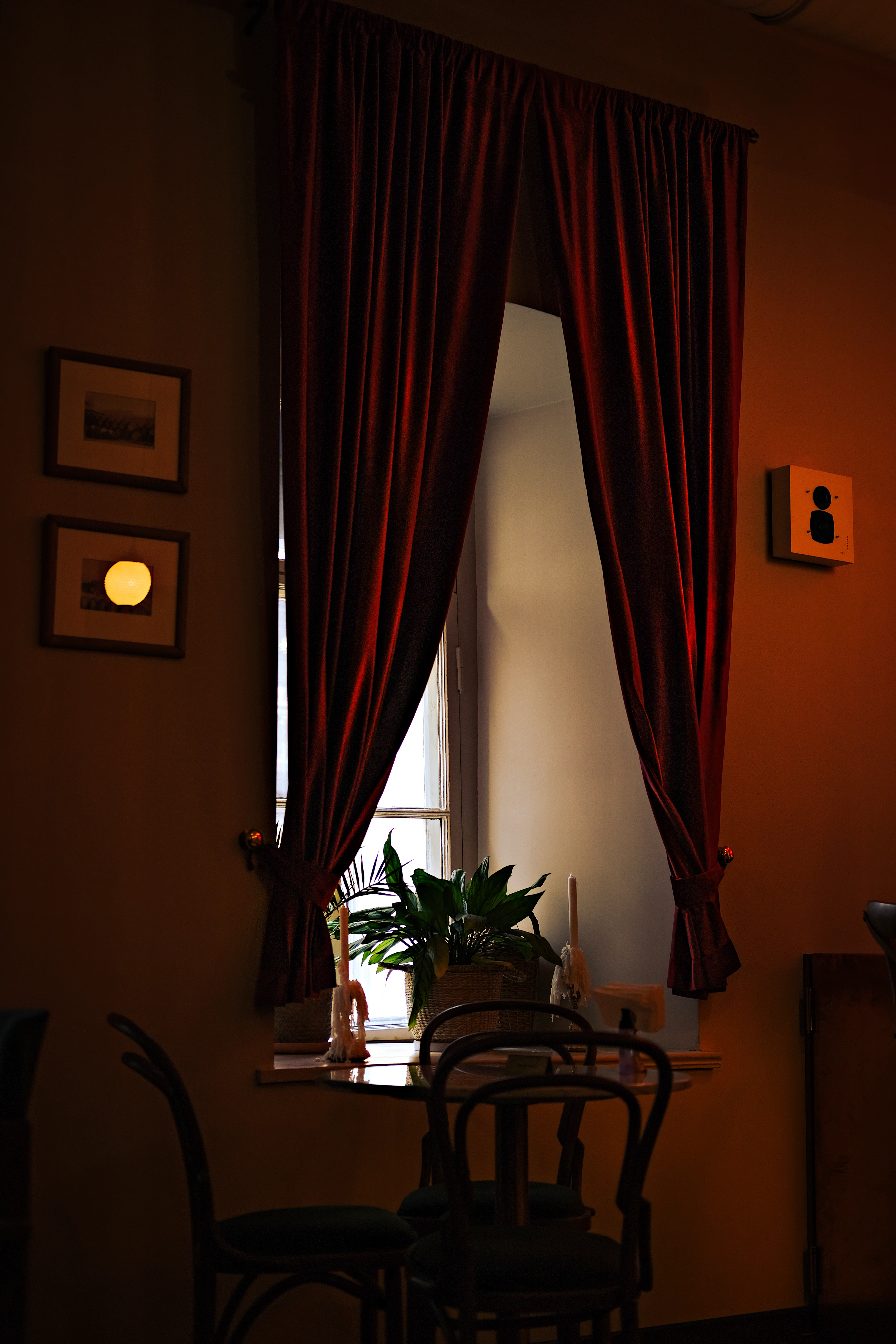 Red window curtain beside a wooden table
