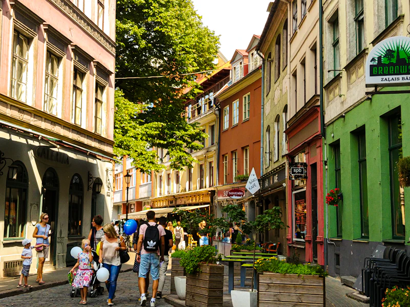 Sunny street with cafés and people walking in Riga Old Town
