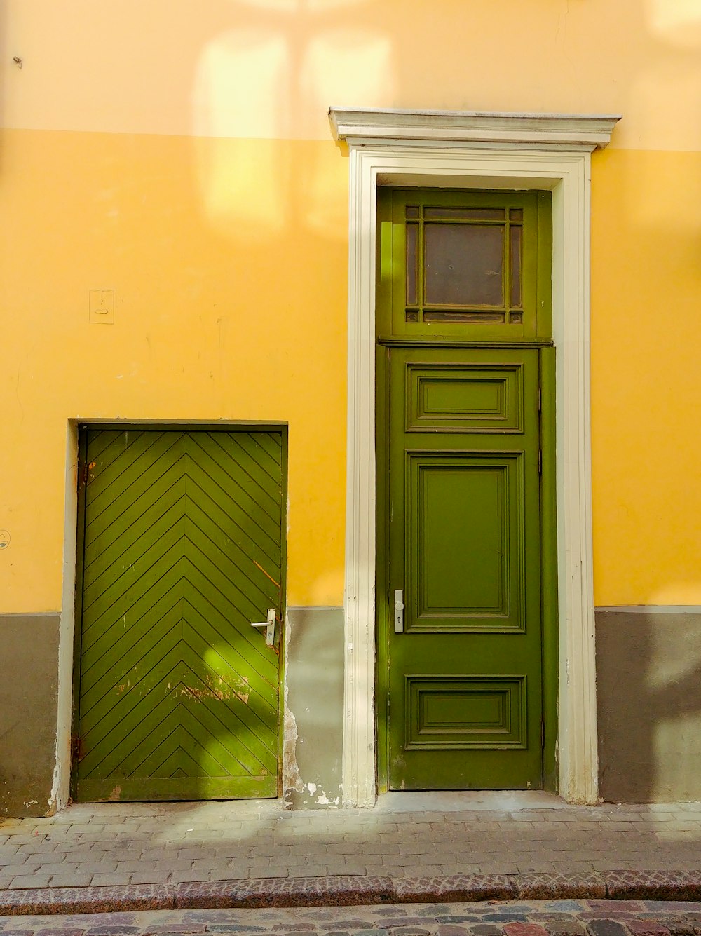 黄色に塗られた壁に黒い木製のドア