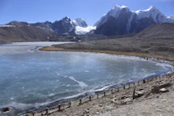 The peaceful Gurudongmar Lake, its icy blue waters reflecting the snow-capped peaks around it.