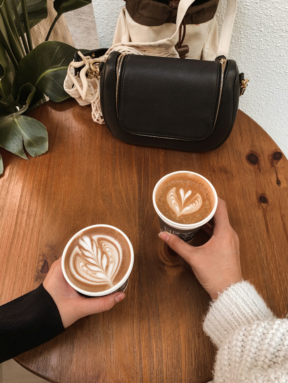 person holding white ceramic mug with cappuccino