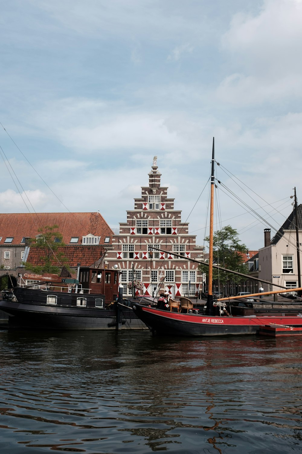 Rotes und schwarzes Boot am Dock in der Nähe des braunen Betongebäudes tagsüber