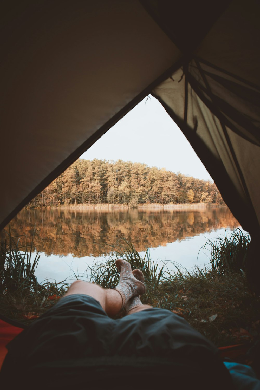 person in gray denim jeans lying inside tent