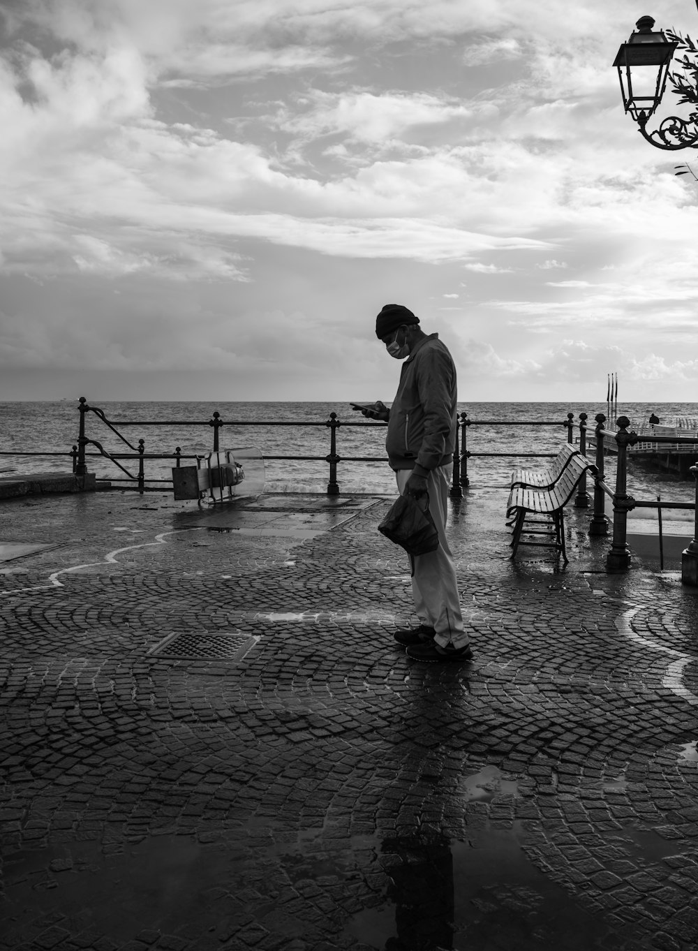 man in white robe walking on wooden dock in grayscale photography