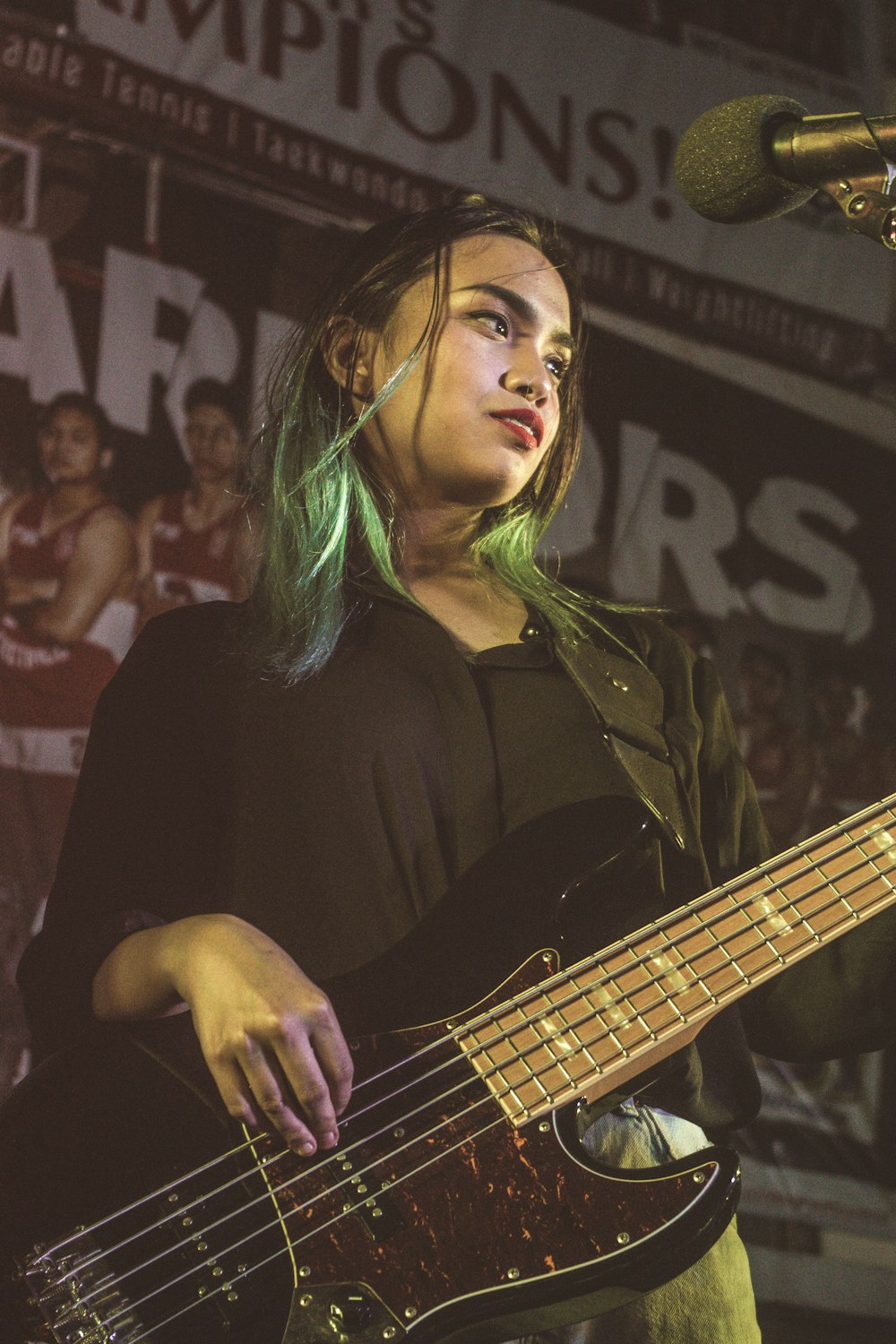 woman in black long sleeve shirt playing guitar