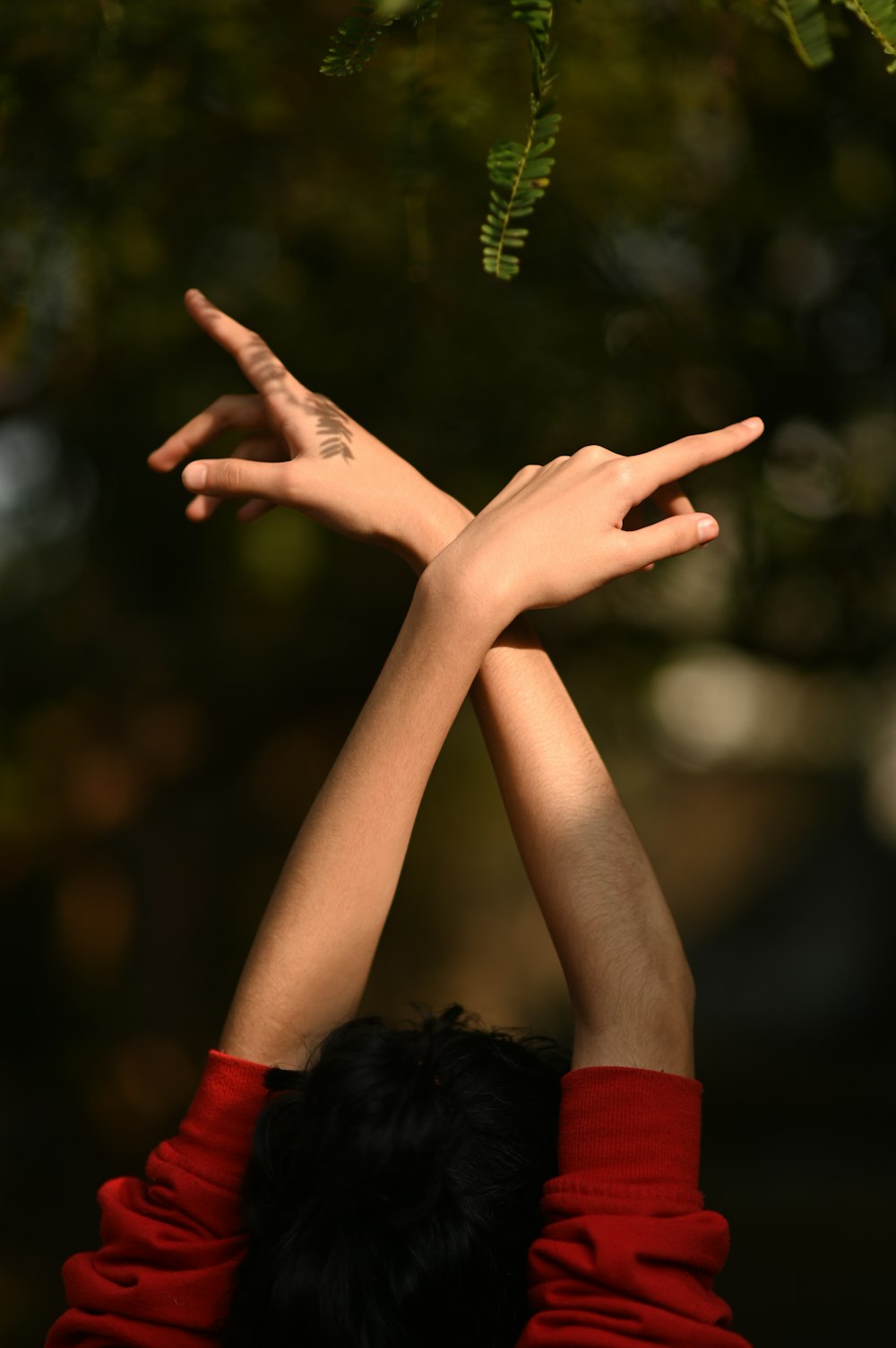 person in red long sleeve shirt raising right hand