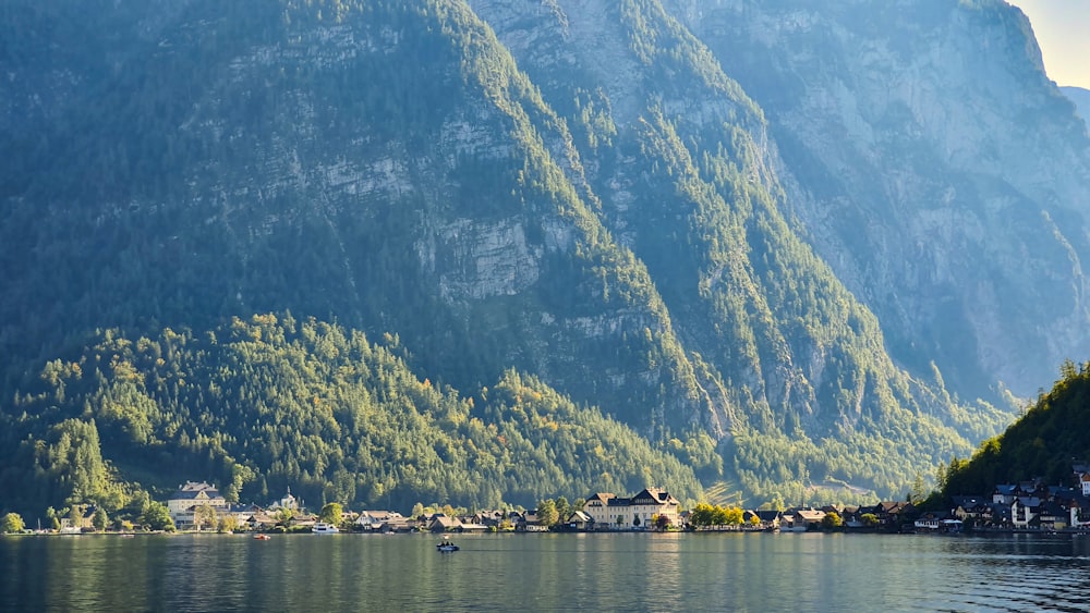 green and white mountain beside body of water during daytime