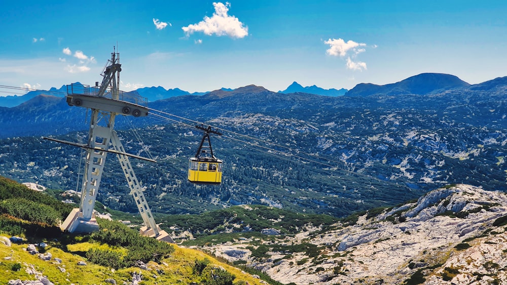 yellow cable car over green grass field during daytime