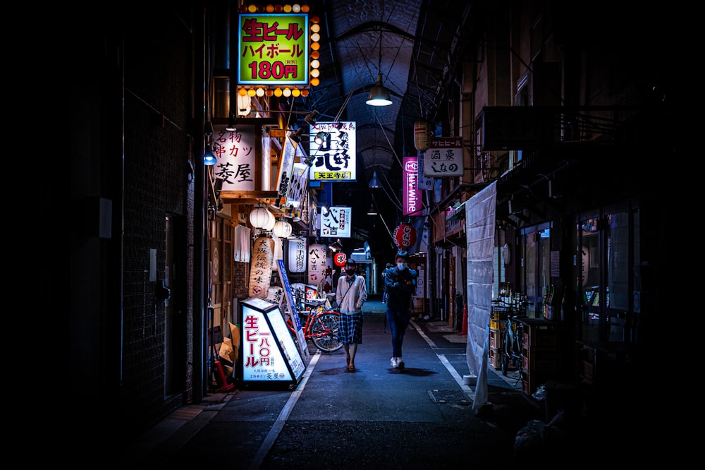 man in black jacket walking on sidewalk during nighttime