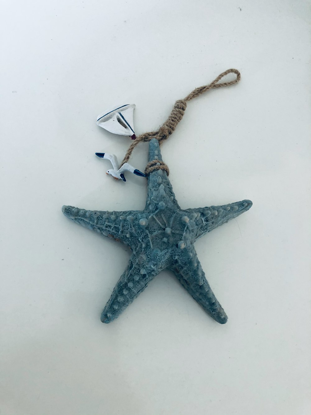 silver star pendant necklace on white surface