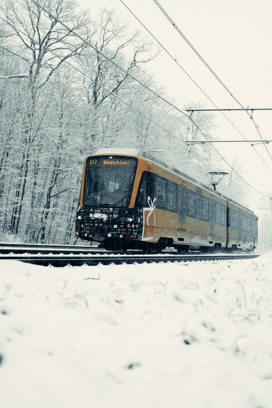 yellow and black train on snow covered ground during daytime