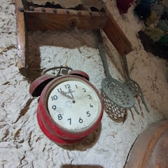 Classic analog thermometer hanging on a kitchen wall with a rustic background.