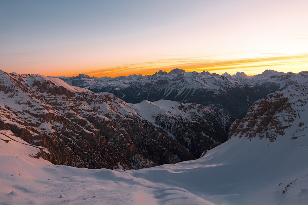 snow covered mountains during sunset