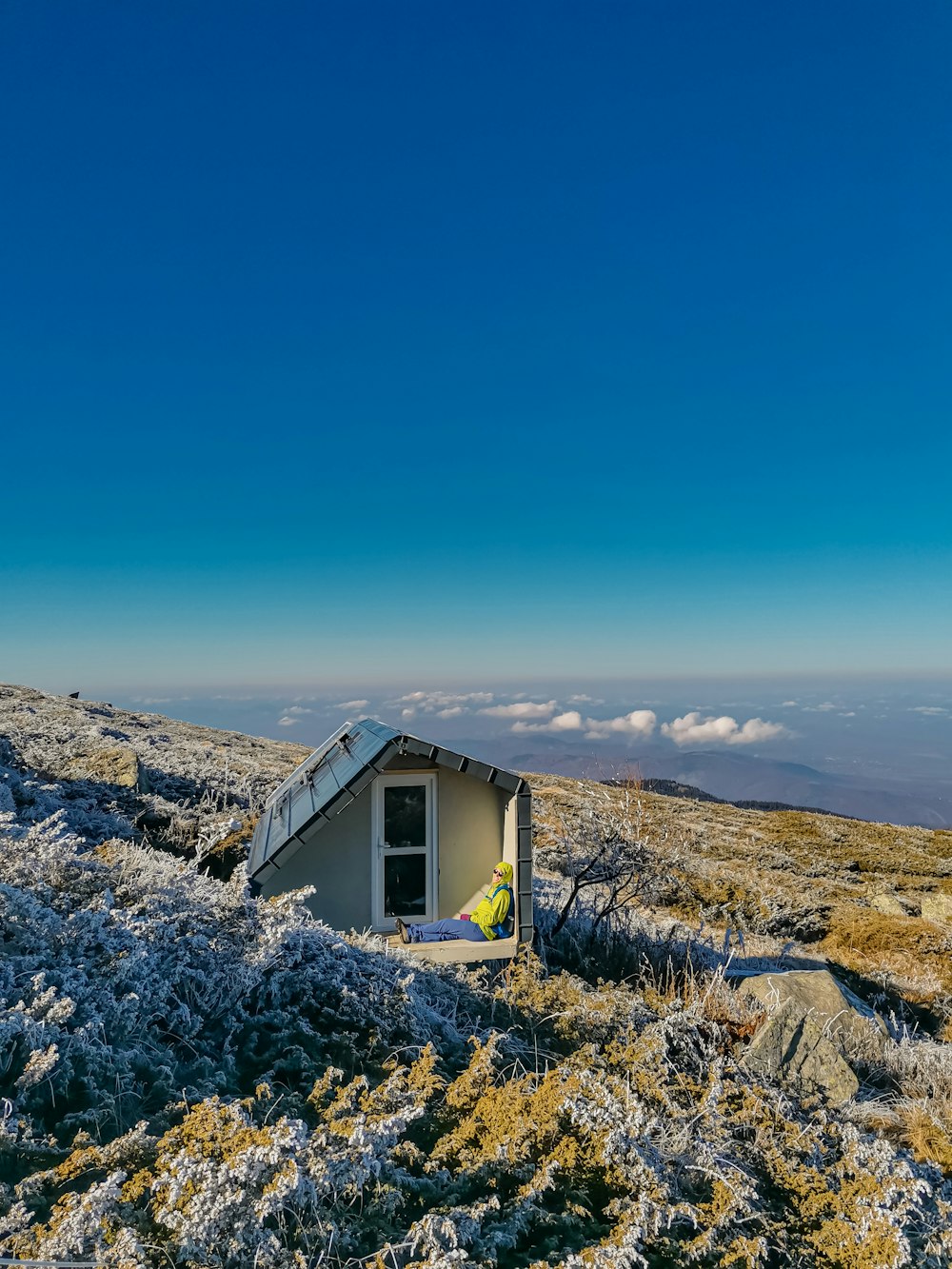 white and brown house on top of hill under blue sky during daytime