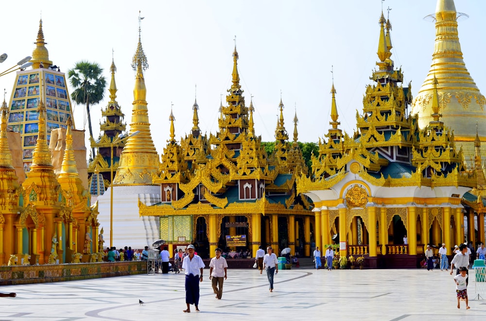 people walking near yellow and white concrete building during daytime