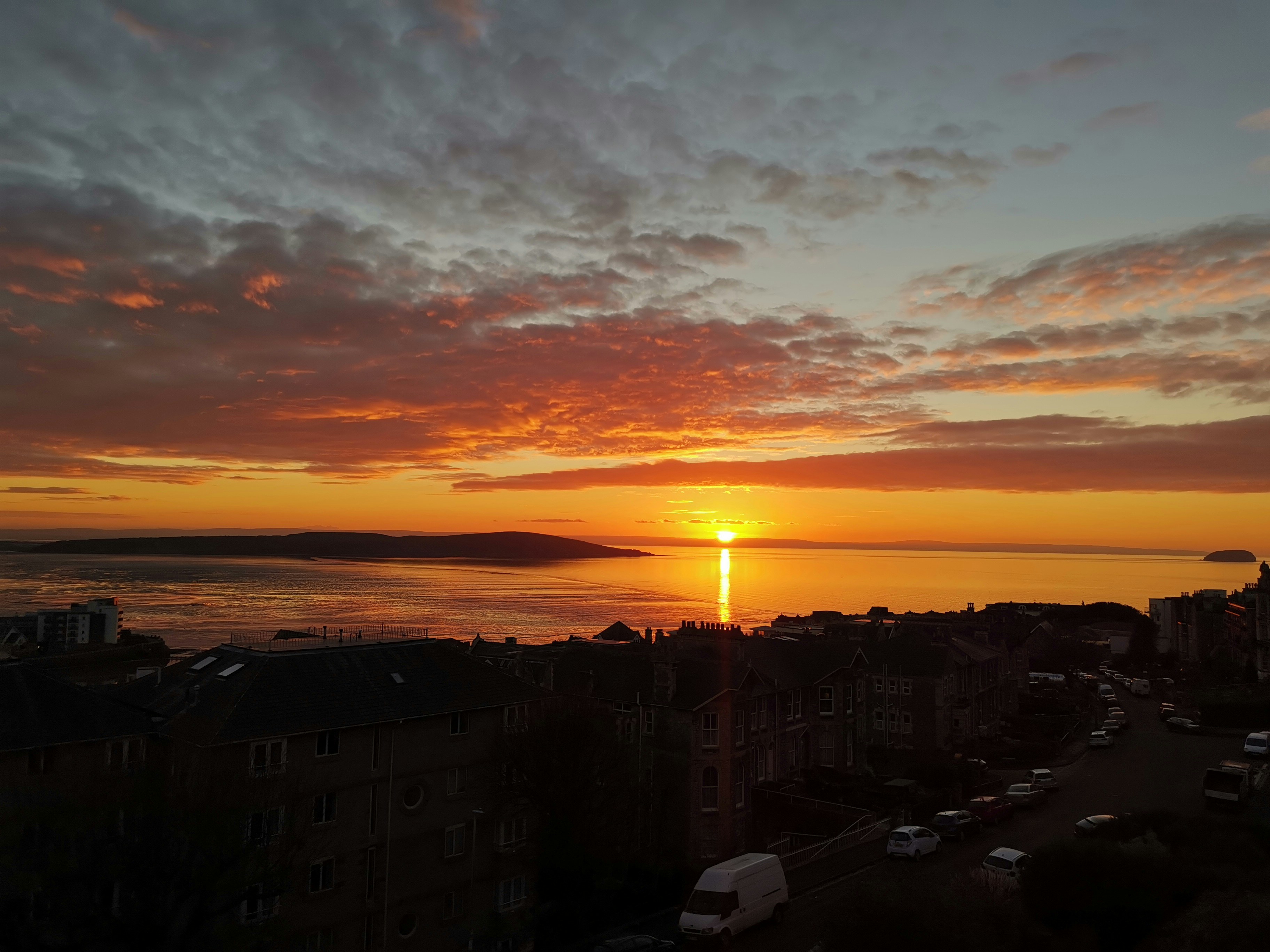 オレンジ色の夕日の下で都市の建物の写真 Unsplashで見つける自然の無料写真