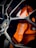Close-up view of a high-performance car brake system, featuring an orange brake caliper with the branding visible, surrounded by a shiny, polished wheel rim.