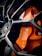 Close-up view of a high-performance car brake system, featuring an orange brake caliper with the branding visible, surrounded by a shiny, polished wheel rim.