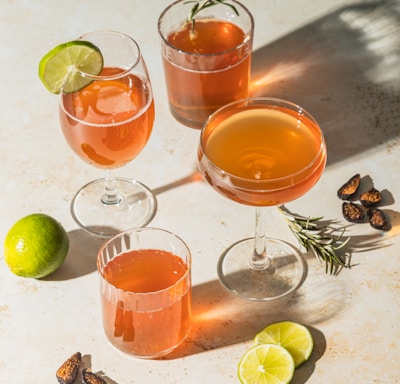 three clear drinking glasses with orange liquid
