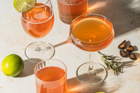 three clear drinking glasses with orange liquid