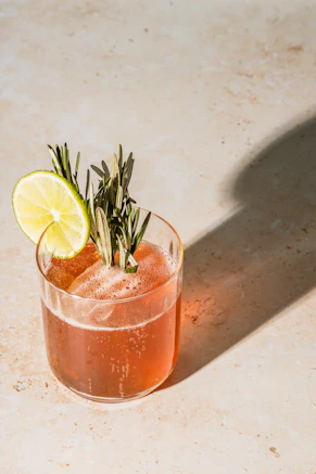 cocktail with lime and rosemary garnish