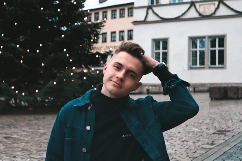 young man in a blue jacket near a building