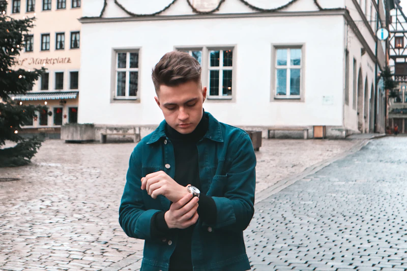 homme en manteau noir marchant sur le trottoir