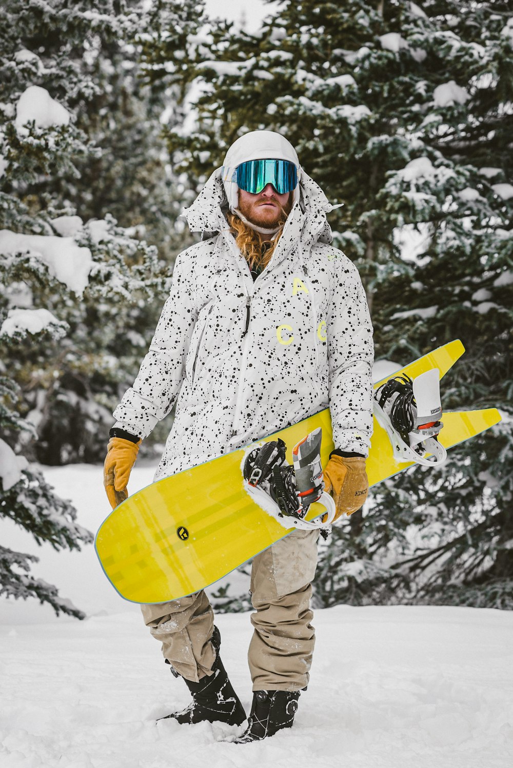 Femme en manteau floral blanc et noir tenant une planche de surf jaune