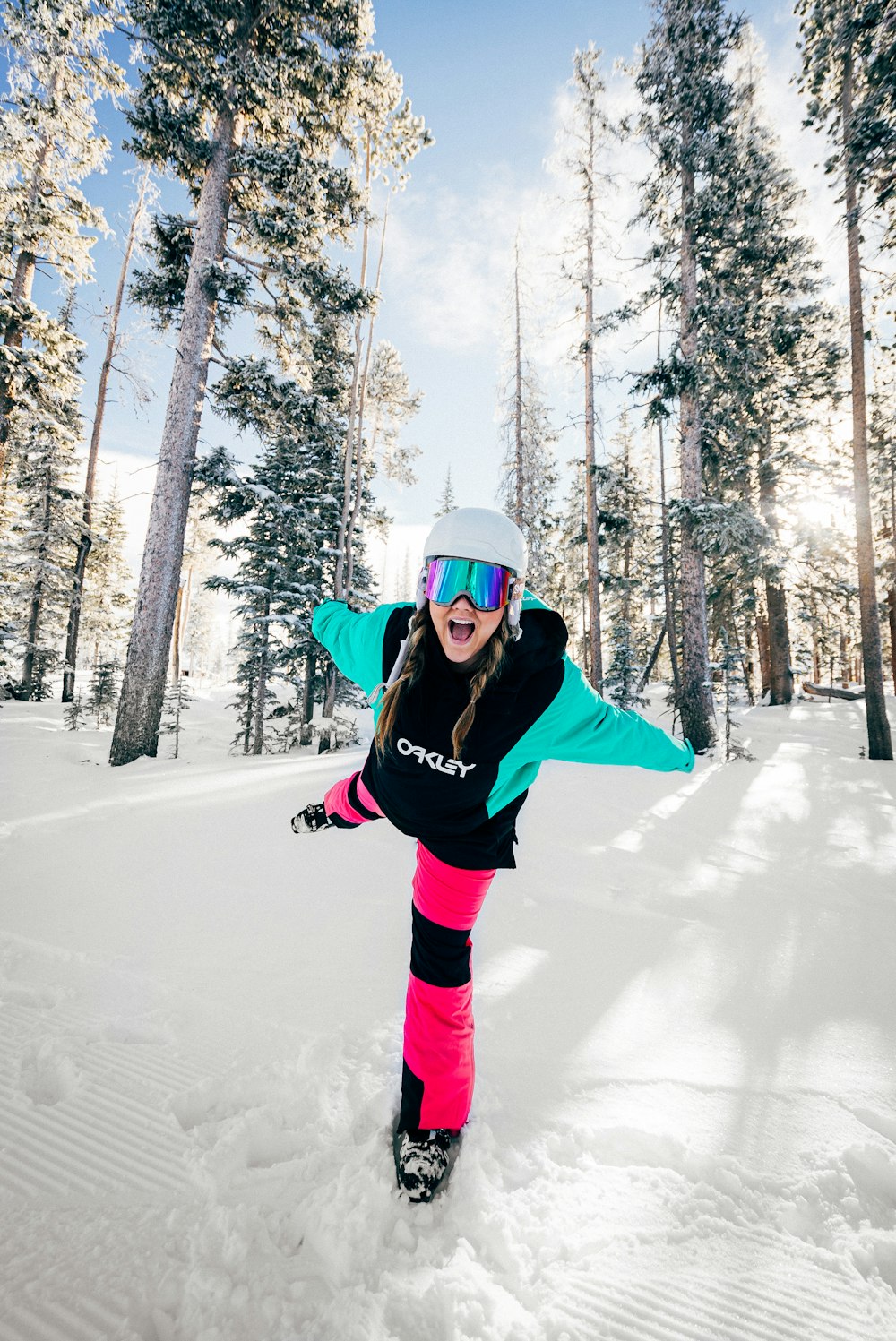 woman in black jacket and pink pants standing on snow covered ground during daytime