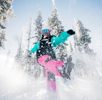 person in blue jacket and pink pants riding on snowboard during daytime