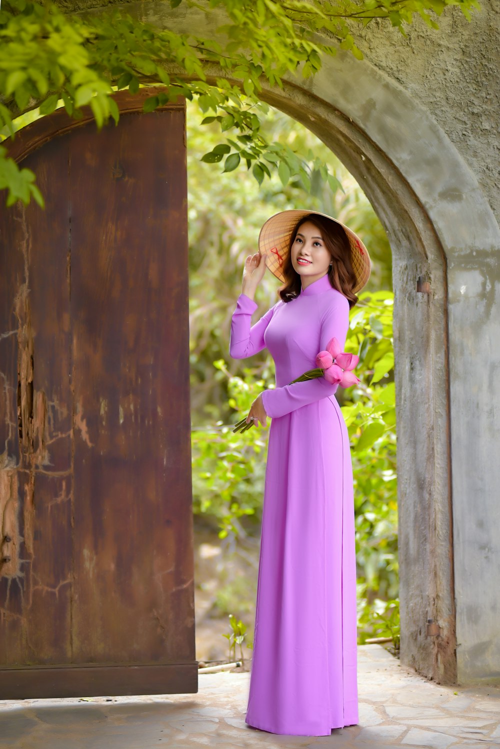 woman in purple long sleeve dress standing beside brown wooden door